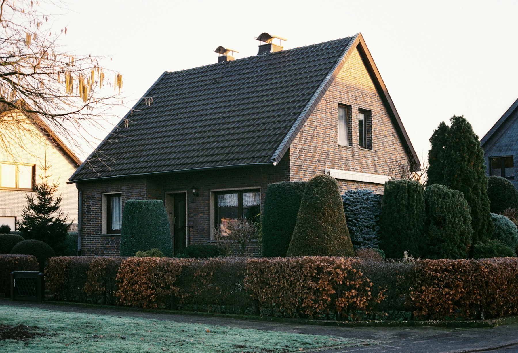 Einfamilienhaus aus rotem Klinker mit Satteldach und gepflegter Hecke im Vorgarten – kleine Renovierungen vor dem Immobilienverkauf - Quelle: Unsplash (Lizenz: Unsplash License)