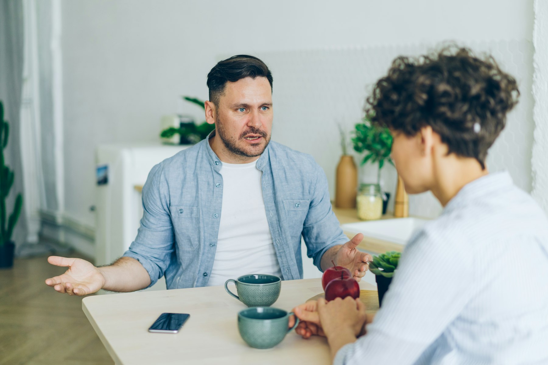Mann und Frau sitzen am Küchentisch und besprechen engagiert eine gemeinsame Entscheidung – Erbengemeinschaft und geerbte Immobilie - Quelle: Unsplash (Lizenz: Unsplash License)