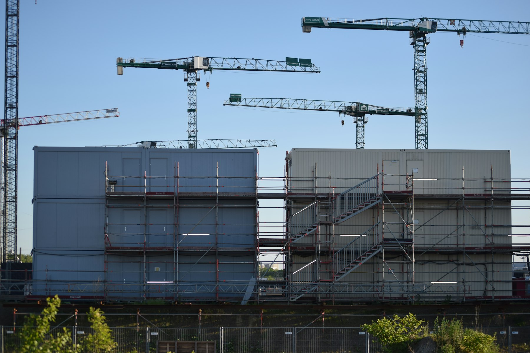 Wohnneubau mit Gerüst und mehreren Baukränen in einem städtischen Umfeld – Baulücke bebauen oder verkaufen - Quelle: Unsplash (Lizenz: Unsplash License)