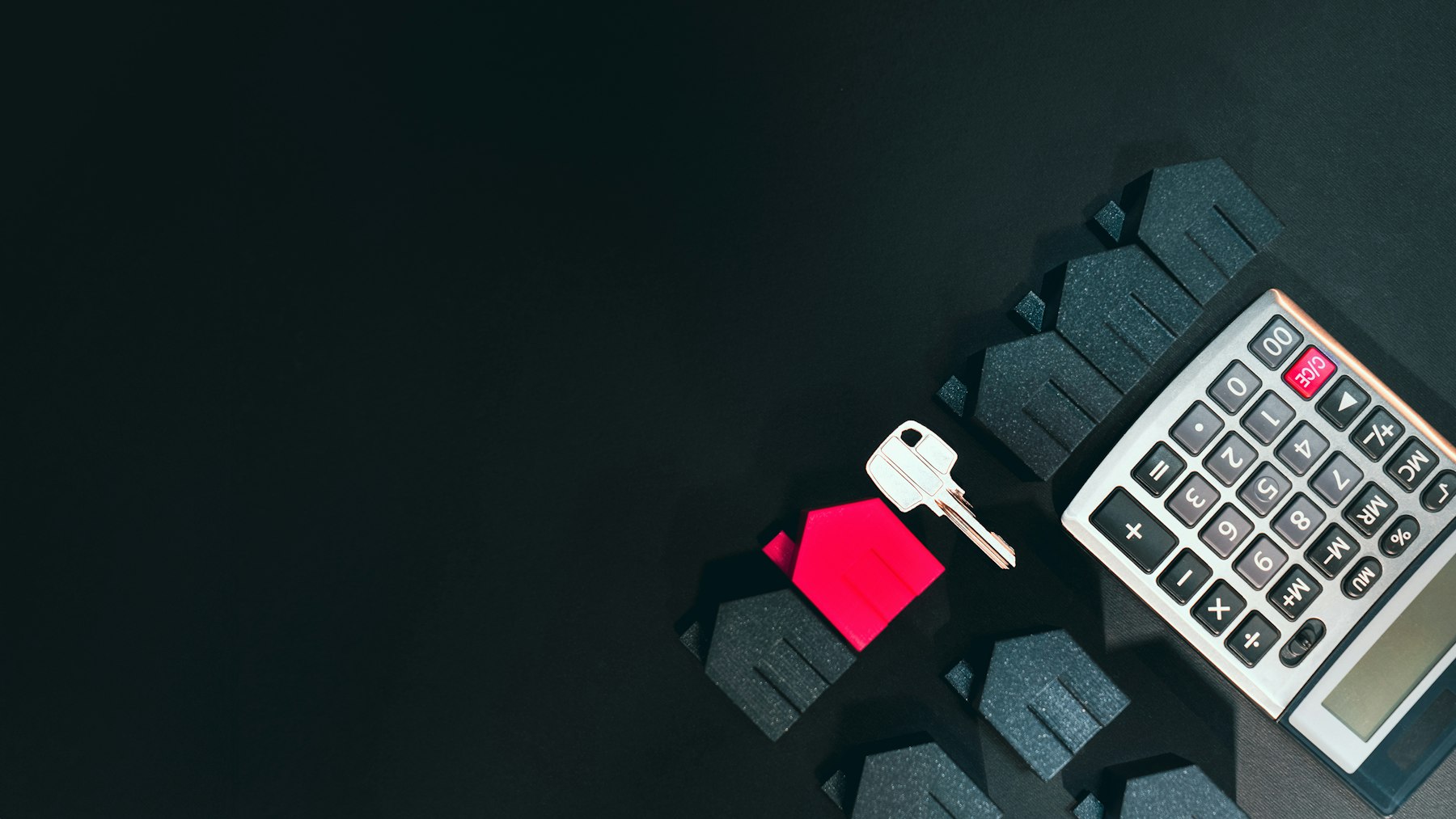 Rotes Hausmodell mit Schlüssel und Taschenrechner – Verkaufspreis einer Immobilie kalkulieren - Quelle: Unsplash (Lizenz: Unsplash License)