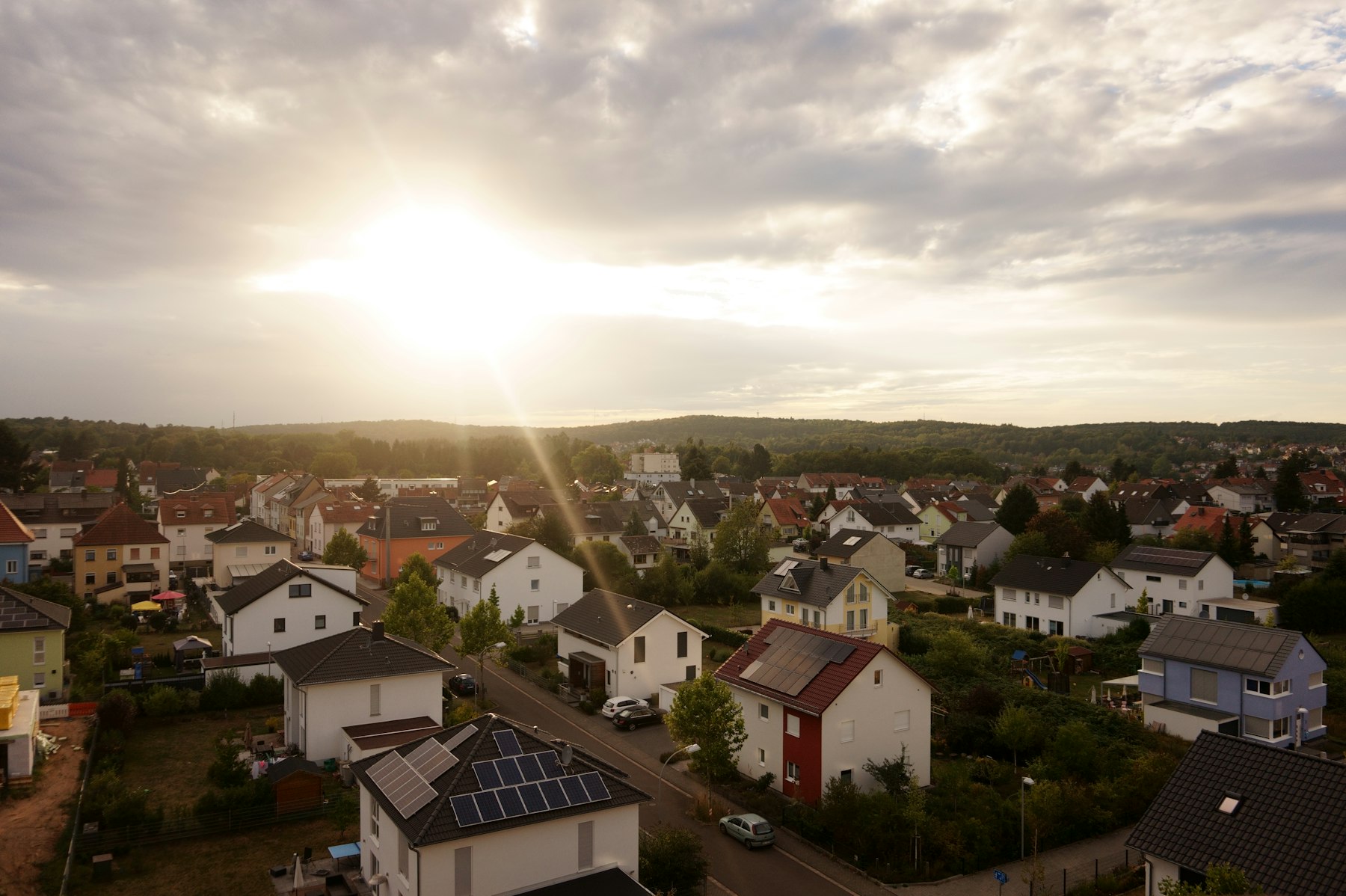 Wohngebiet mit Einfamilienhäusern und Gärten im Abendlicht – Grundstück mit Baulasten verkaufen - Quelle: Unsplash (Lizenz: Unsplash License)